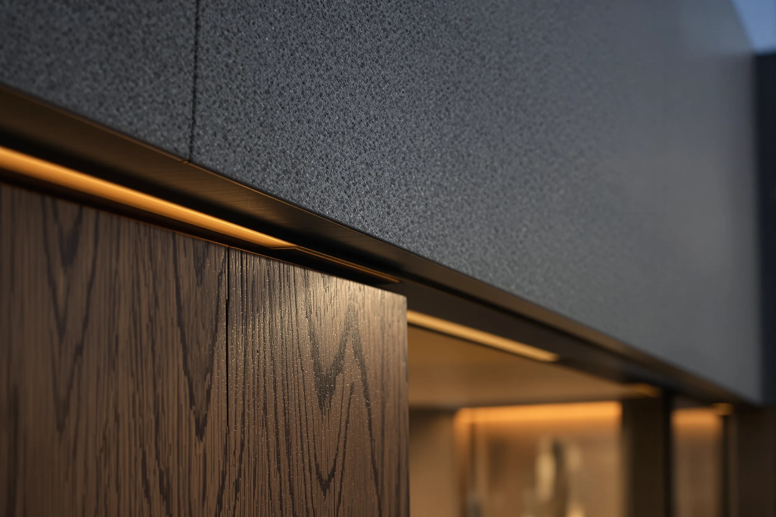 An architectural detail of board-marked concrete meeting warm oak and a slim brass reveal